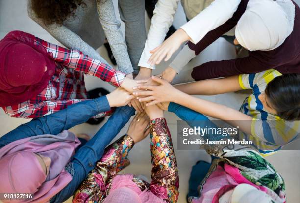 top view of muslim diverse friends in circle with hands together - religion stock-fotos und bilder