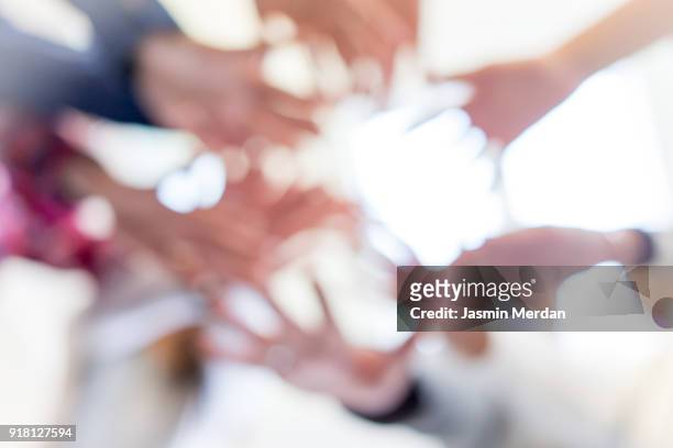 abstract blurred hands together - smiling controluce foto e immagini stock