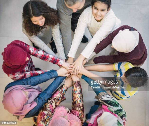 top view of muslim diverse friends in circle with hands together - vestimenta religiosa imagens e fotografias de stock
