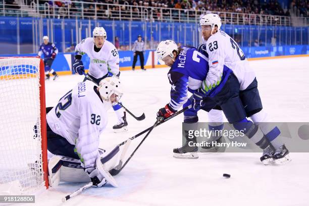 John McCarthy of the United States skates against Luka Vidmar of Slovenia during the Men's Ice Hockey Preliminary Round Group B game on day five of...