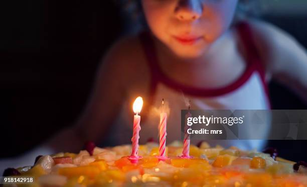 girl blowing out candles on her birthday cake - birthday cake lots of candles 個照片及圖片檔