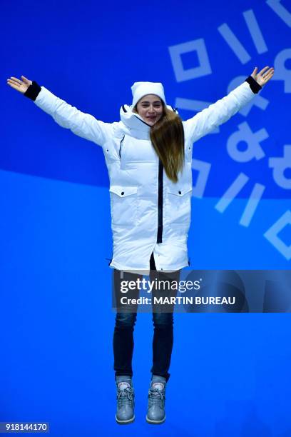 Russia's bronze medallist Yulia Belorukova jumps on the podium during the medal ceremony for the women's cross country sprint classic at the...