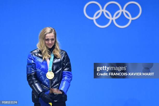 Sweden's gold medallist Stina Nilsson cries of joy on the podium during the medal ceremony for the women's cross country sprint classic at the...