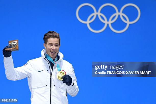 S gold medallist Shaun White poses on the podium during the medal ceremony for the men's snowboard halfpipe at the Pyeongchang Medals Plaza during...