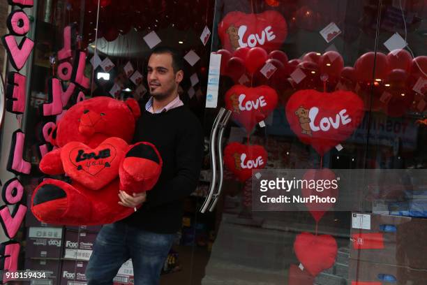 Palestinians walk past a shop selling gifts for Valentine's Day in Gaza City, Feb. 14, 2018.