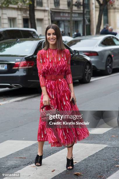 Fashion blogger Camila Coelho wears a Valentino dress and bag, Louis Vuitton belt and Gianvito Rossi shoes day 6 of Paris Womens Fashion Week...