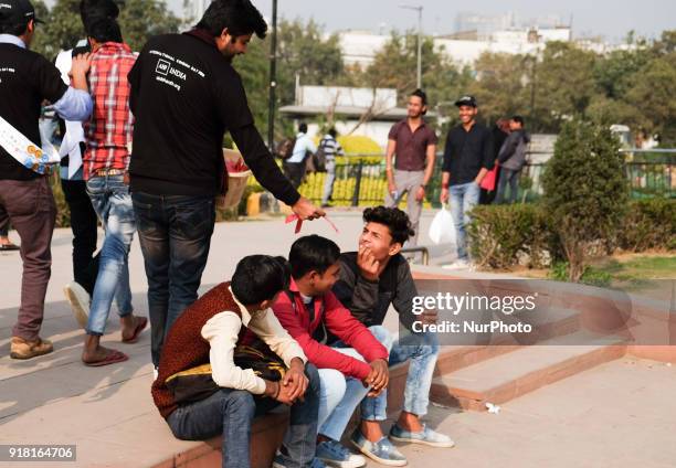 Volunteers distribute free condoms to general public during an event to mark International Condom Day in New Delhi on February 13, 2018. The event...