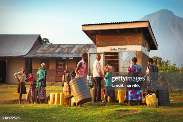 habitants d’attente pour obtenir l’eau potable dans le village ouganda - récipient sous pression photos et images de collection
