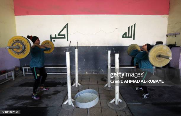 Iraqi weightlifters Angian Hazem and Haiyt Karim train on January 18, 2018 at a club in Sadr City, east of Baghdad. - The weightlifters on Iraq's...