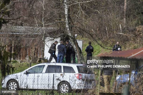 Gendarmes and forensic experts search a garden cabin along a road near Domessin in the Eastern French region of Savoie on February 14 in relation...
