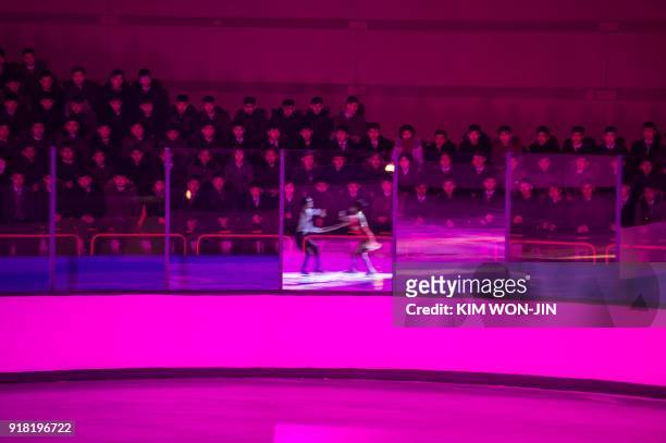 Spectators watch as figure skaters perform during the opening ceremony of a figure skating festival marking the anniversary of the birth of late...