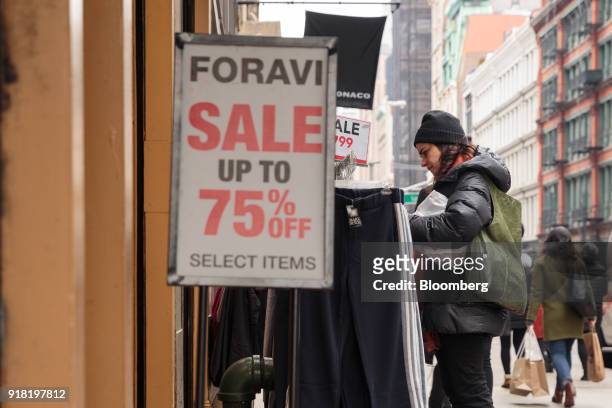 Shopper views a rack of clothing hanging on display for sale in front of a store in the SoHo neighborhood of New York, U.S., on Friday, Feb. 9, 2018....