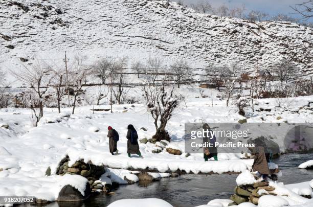 People walking on a footbridge over a stream in Daksum, about 97 kilometers south of Srinagar city, the summer capital of Indian-controlled Kashmir,...