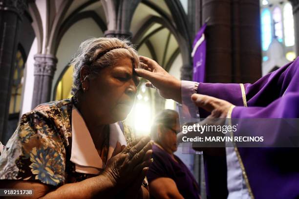Catholic faithful has her forehead marked during the celebration of Ash Wednesday in El Calvario parish in San Salvador, on February 14, 2018. Ash...