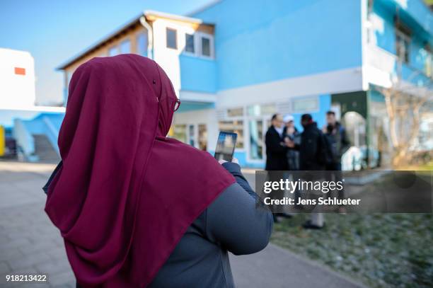 Muslim woman stands in front of the Muslim cultural center and mosque following a recent attack just before the beginning of the visit of Aydan...