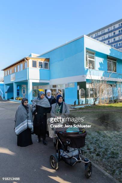 Muslim women stand in front of the Muslim cultural center and mosque following a recent attack just before the beginning of the visit of Aydan Ozoguz...