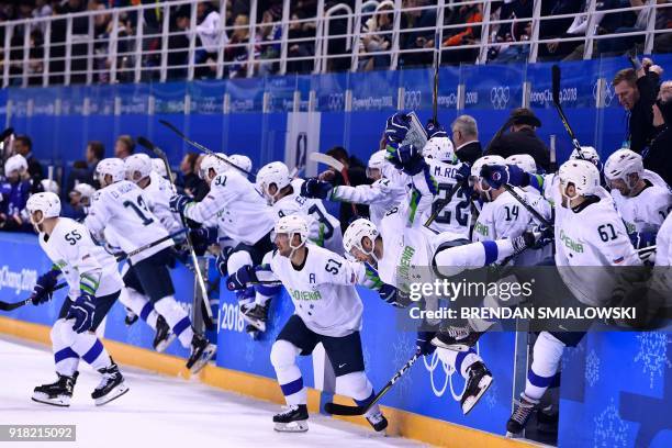 Team Slovenia rushes the ice after an overtime win of a men's preliminary round ice hockey match between the United States and Slovenia during the...