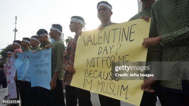 Indonesian muslim students holds a banners during an anti-Valentine protest in Banda Aceh, Indonesia, on February 14, 2018. Islamic conservatives in...