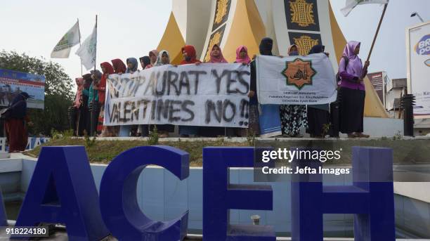 Indonesian muslim students holds a banners during an anti-Valentine protest in Banda Aceh, Indonesia, on February 14, 2018. Islamic conservatives in...