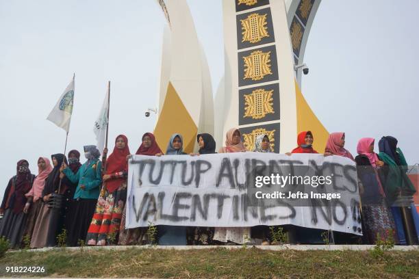 Indonesian muslim students holds a banners during an anti-Valentine protest in Banda Aceh, Indonesia, on February 14, 2018. Islamic conservatives in...