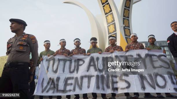 Indonesian muslim students holds a banners during an anti-Valentine protest in Banda Aceh, Indonesia, on February 14, 2018. Islamic conservatives in...