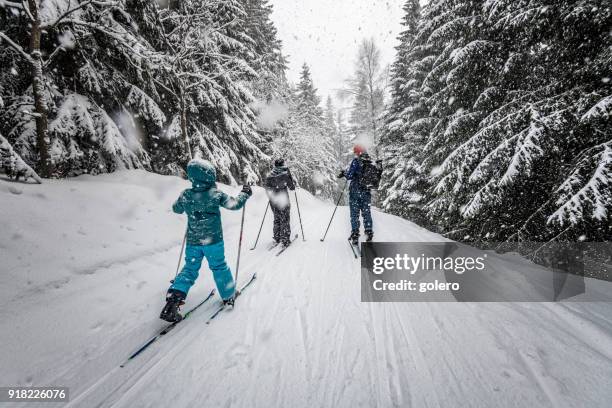 family in snowy winter landscape on cross-country-ski - kid skiing stock pictures, royalty-free photos & images