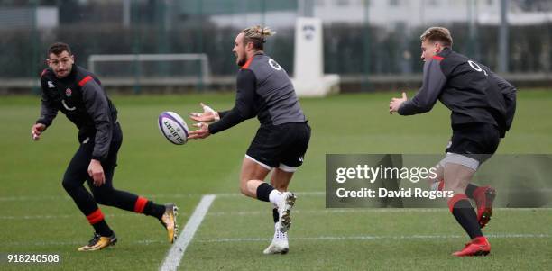 Jack Nowell passes the ball watched by Jonny May and Harry Mallinder during the England training session held at Latyer Upper School on February 14,...