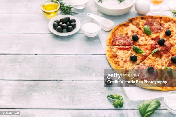 italian pizza with pepperoni and toppings on wooden background - toppings stock pictures, royalty-free photos & images