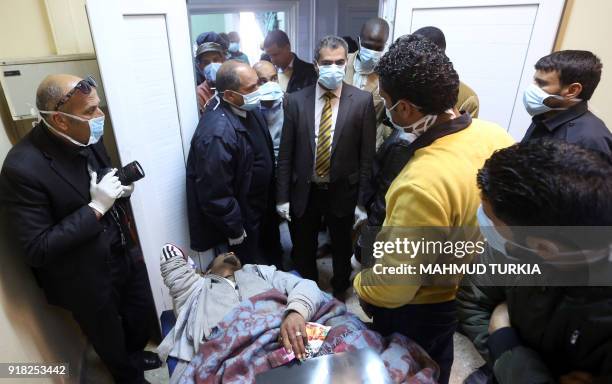 Colonel Mohamed Bashir, director of Libya's Illegal Immigration Control Agency, checks on an African mgirant who was injured after their vehicle was...