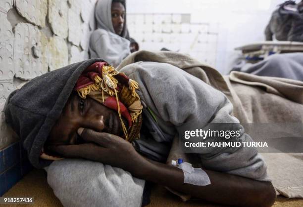 An African migrant who was injured after their vehicle was overturned during a truck collision, lies in a room after receiving medical treatment at a...