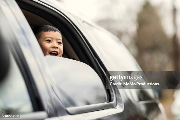 boy (4yrs) looking out of car window - car window stockfoto's en -beelden
