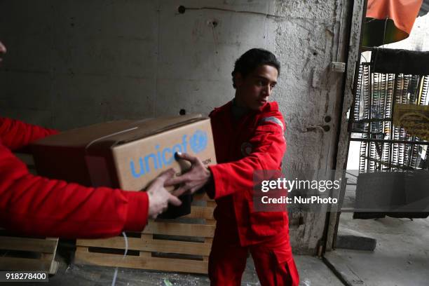 Syrian Arab Red Crescent volunteers offload aid from a lorry after an aid convoy arrived in the town of Douma, in the Syrian rebel enclave of Eastern...