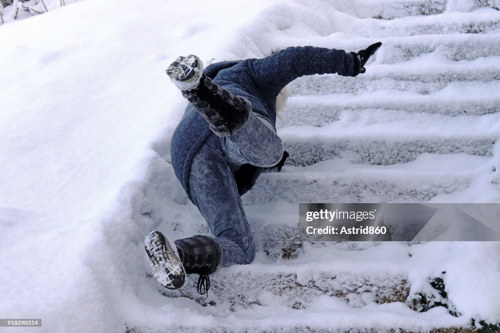 A woman slips and fell on a wintry staircase