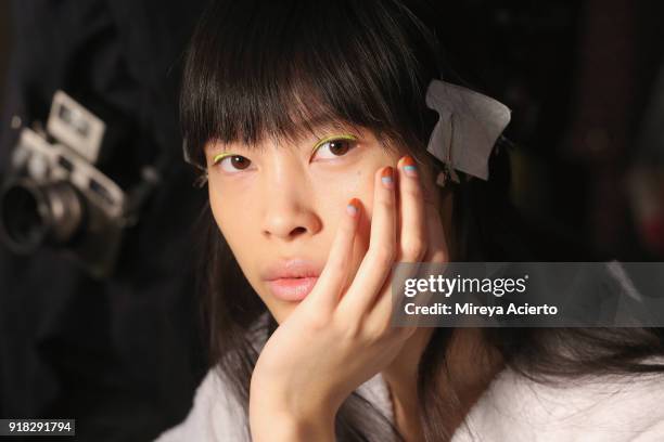 Model prepares backstage at the Maryam Nassir Zadeh fashion show during New York Fashion Week on February 14, 2018 in New York City.