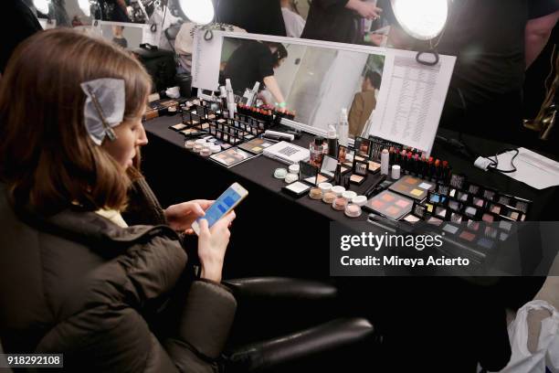 Model prepares backstage at the Maryam Nassir Zadeh fashion show during New York Fashion Week on February 14, 2018 in New York City.