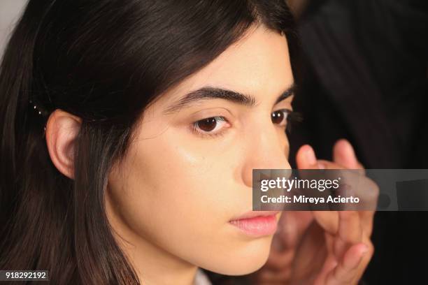 Model prepares backstage at the Maryam Nassir Zadeh fashion show during New York Fashion Week on February 14, 2018 in New York City.