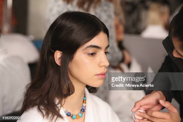 Model prepares backstage at the Maryam Nassir Zadeh fashion show during New York Fashion Week on February 14, 2018 in New York City.