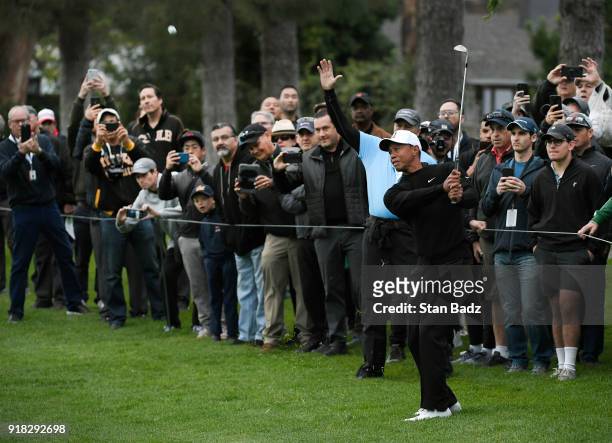 Fans photograph Tiger Woods playing his third shot on the first hole during practice for the Genesis Open at Riviera Country Club on February 14,...