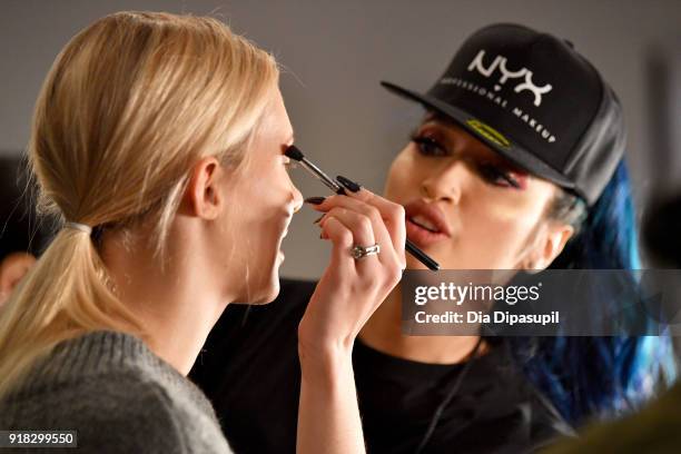 Stylist prepares a model backstage for Marcel Ostertag during New York Fashion Week: The Shows at Gallery II at Spring Studios on February 14, 2018...