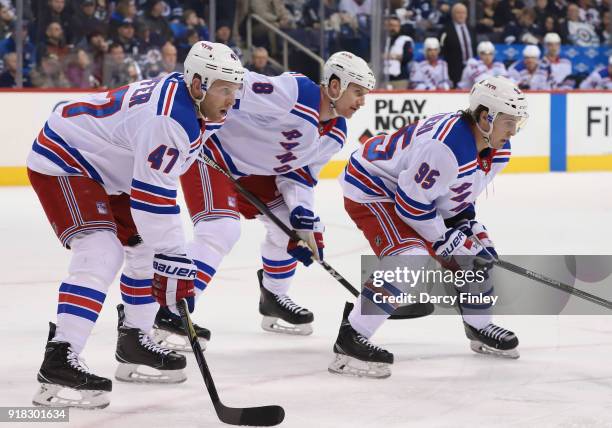 Steven Kampfer, Cody McLeod and Vinni Lettieri of the New York Rangers get set for a first period face-off against the Winnipeg Jets at the Bell MTS...
