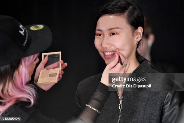 Model prepares backstage for Marcel Ostertag during New York Fashion Week: The Shows at Gallery II at Spring Studios on February 14, 2018 in New York...