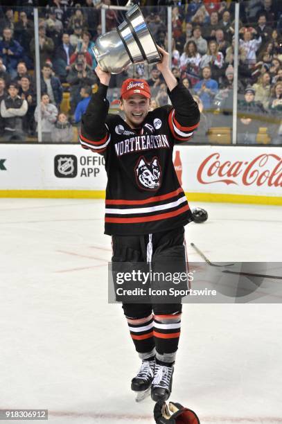 Northeastern Huskies defenseman Garrett Cecere hoist the Beanpot trophy .During the Northeastern Huskies game against the Boston University Terriers...