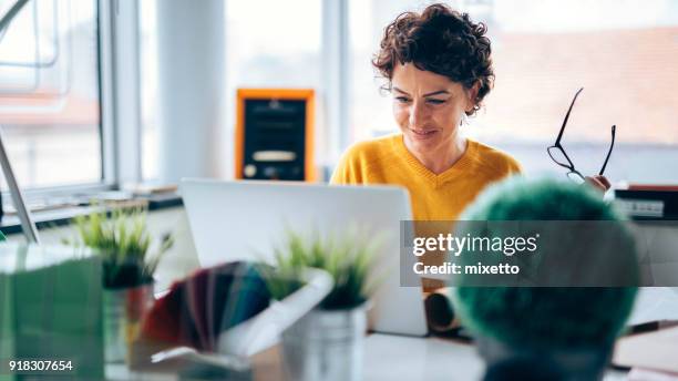 bon travail - femme assise bureau photos et images de collection