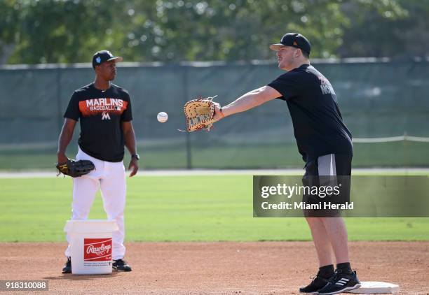 Former Miami Marlins Juan Pierre looks on as first baseman Justin Bour catches a ball during the spring training baseball workouts for pitchers and...