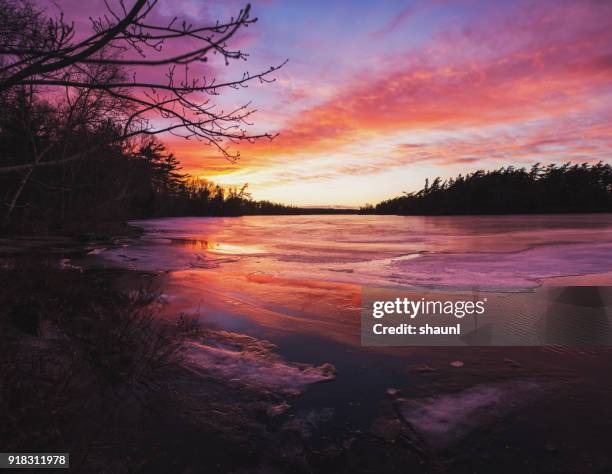 sunset on frozen lake - frozen lake sunset stock pictures, royalty-free photos & images