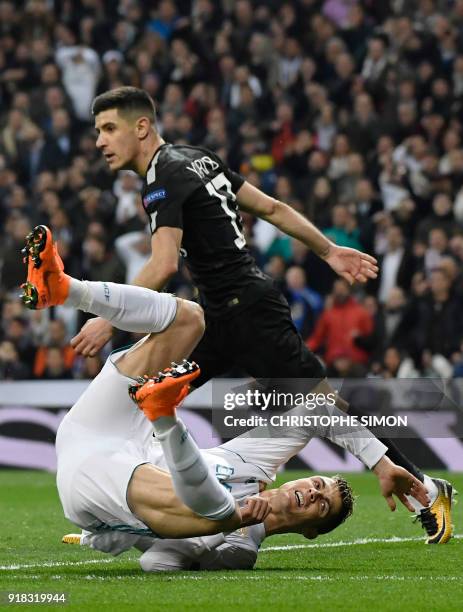 Real Madrid's Portuguese forward Cristiano Ronaldo falls down beside Paris Saint-Germain's Spanish defender Yuri Berchiche during the UEFA Champions...