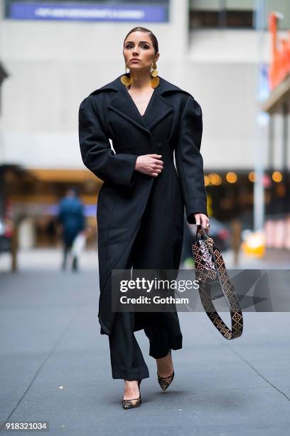 Olivia Culpo is seen wearing a Jacquemus coat, Johanna Ortiz jumpsuit with Jimmy Choo shoes and a Dior handbag in Midtown on February 14, 2018 in New...