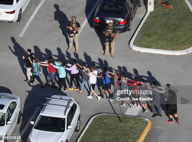 People are brought out of the Marjory Stoneman Douglas High School after a shooting at the school that reportedly killed and injured multiple people...