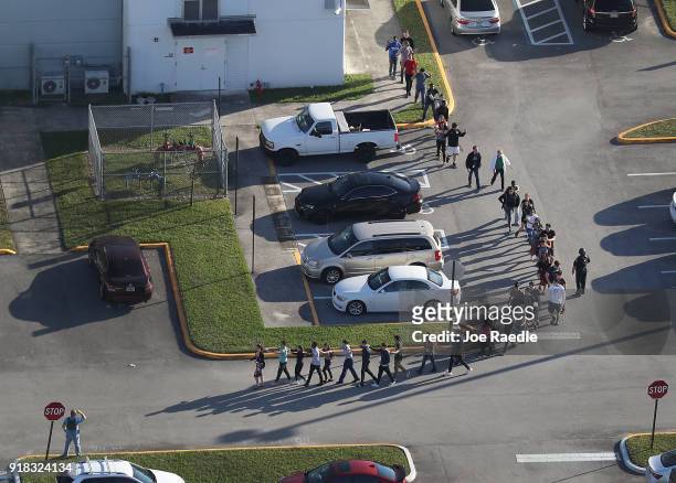 People are brought out of the Marjory Stoneman Douglas High School after a shooting at the school that reportedly killed and injured multiple people...