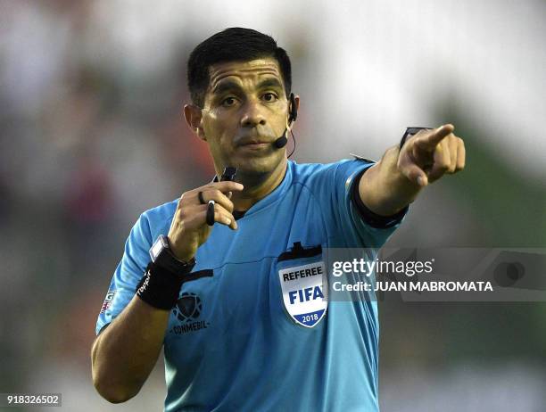 Paraguayan referee Enrique Caceres gestures during the Copa Libertadores 3rd stage first leg football match between Argentina's Banfield and...